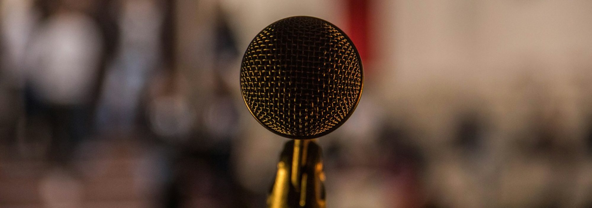 selective focus photography of brass-colored microphone
